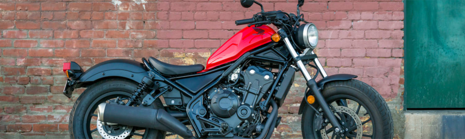 A Honda® motorcycle that's parked next to a brick building