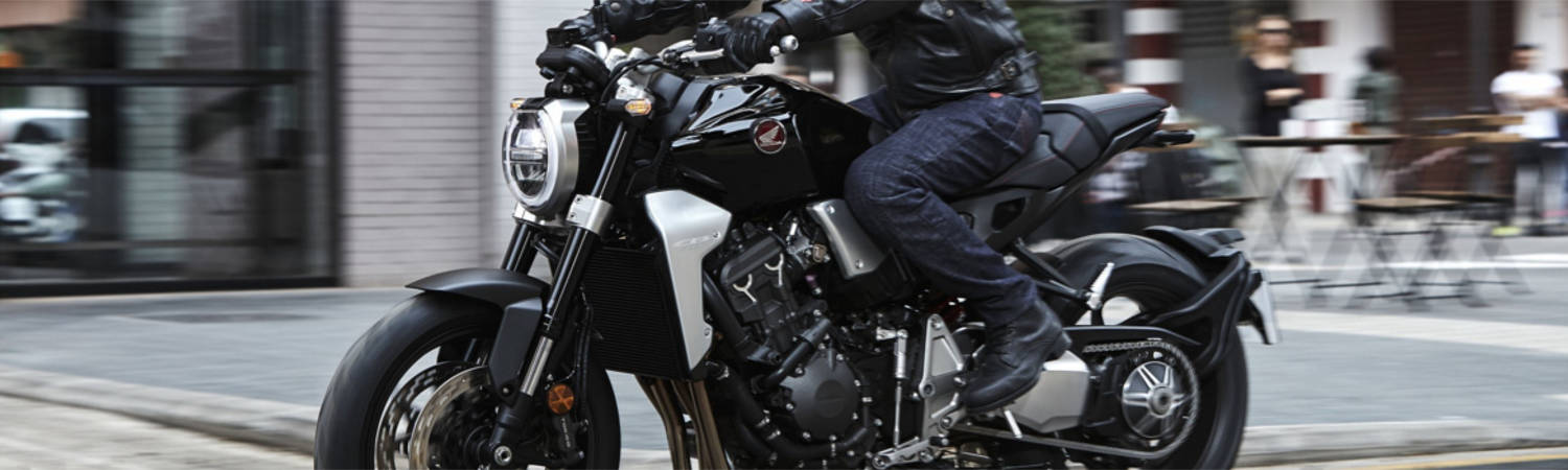 A person riding a Honda® sport bike down a city street